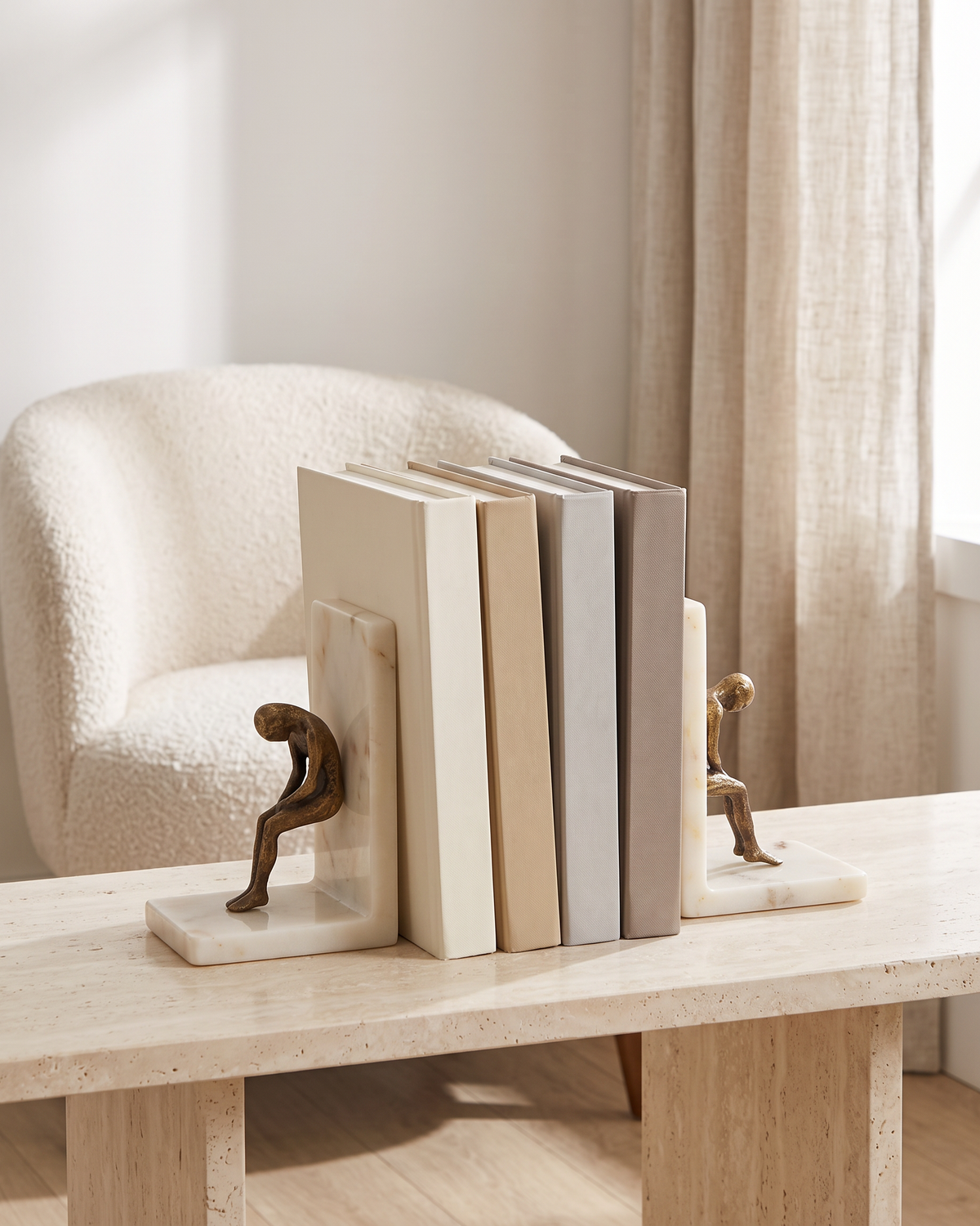 Thinking Man Bookend Set on Marble Base, Modern Literary Shelf Decor - styled on a travertine console holding plain books
