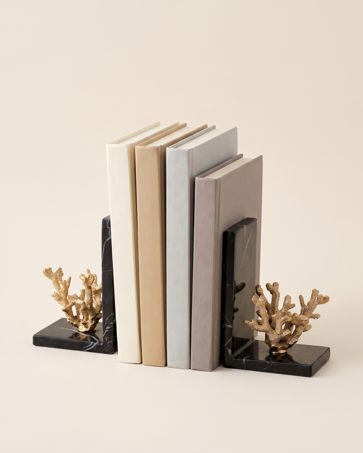 Golden Coral Bookends with Black Marble Base - studio view on ivory background, holding a row of plain books