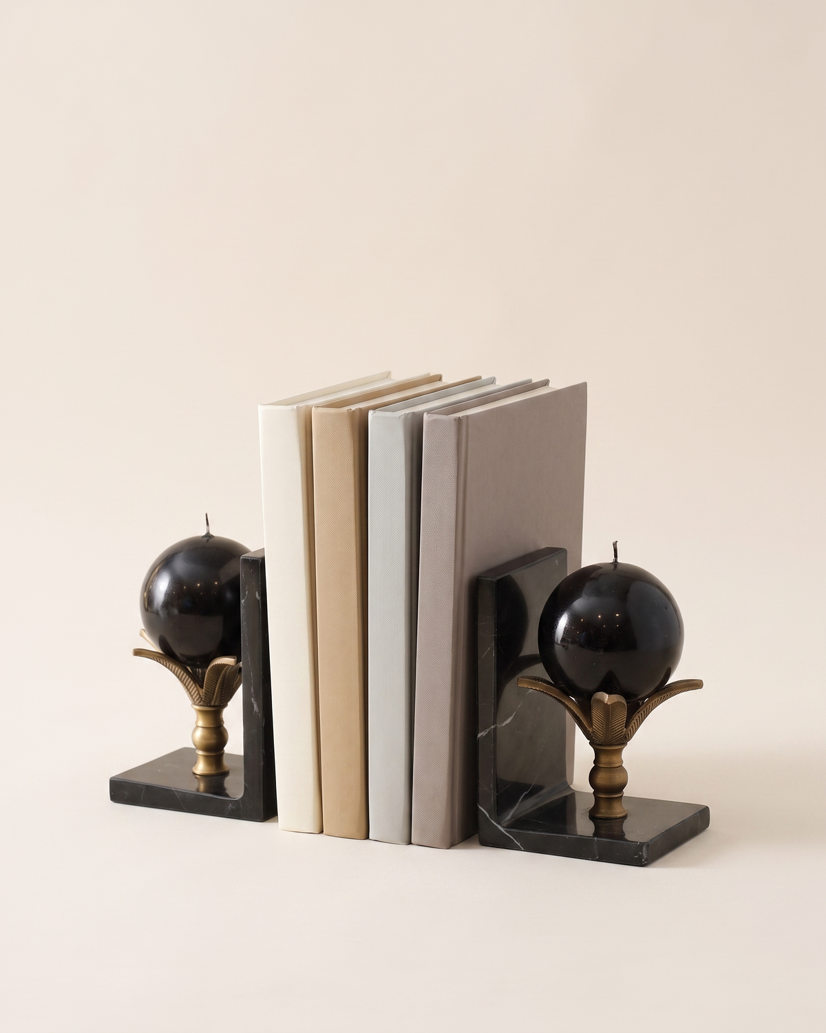 Lotus Sphere Marble Bookends - studio view on ivory background, holding a row of plain books