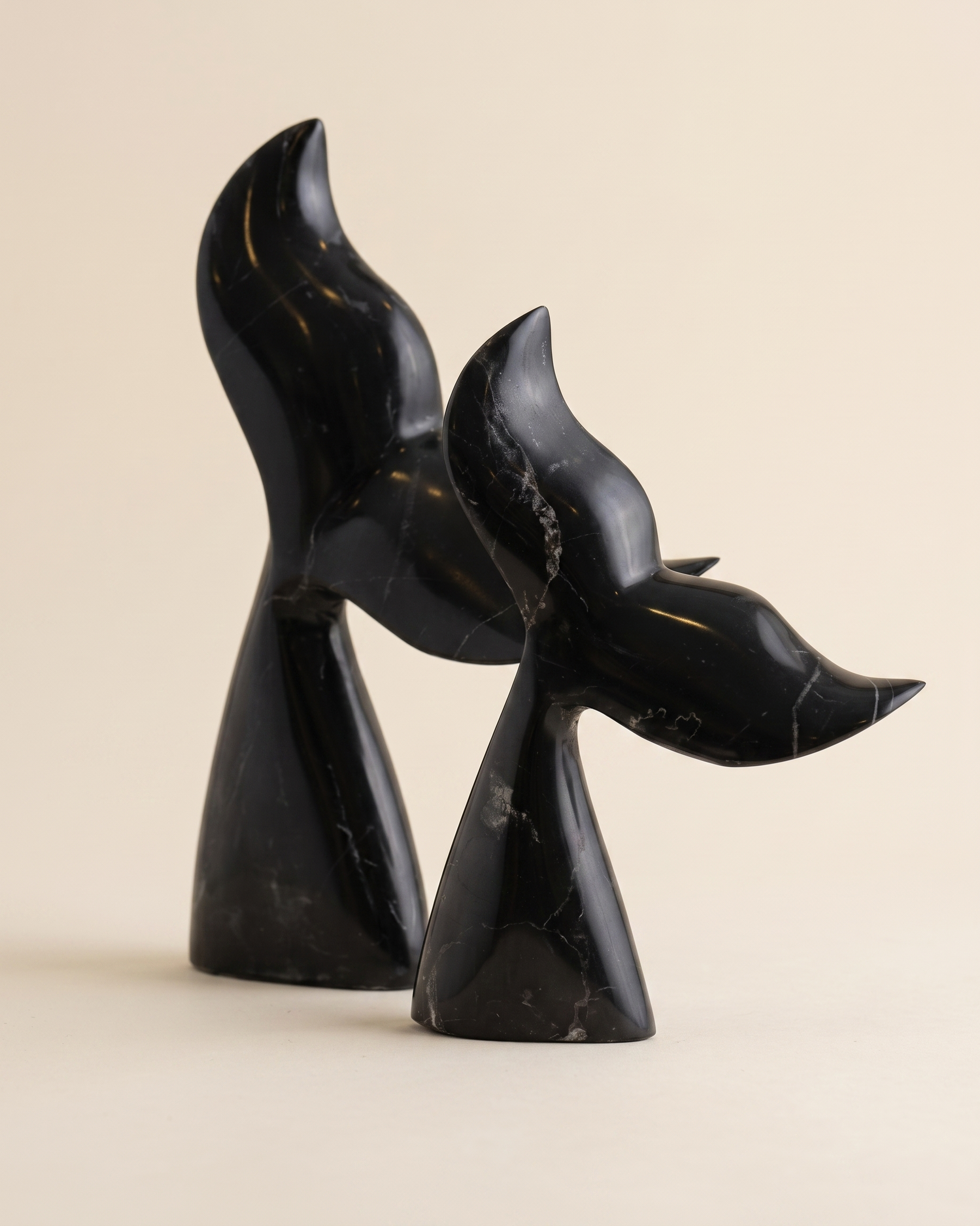 Whale Tail Decorative Object IV - two black marble whale tail sculptures, ivory studio background