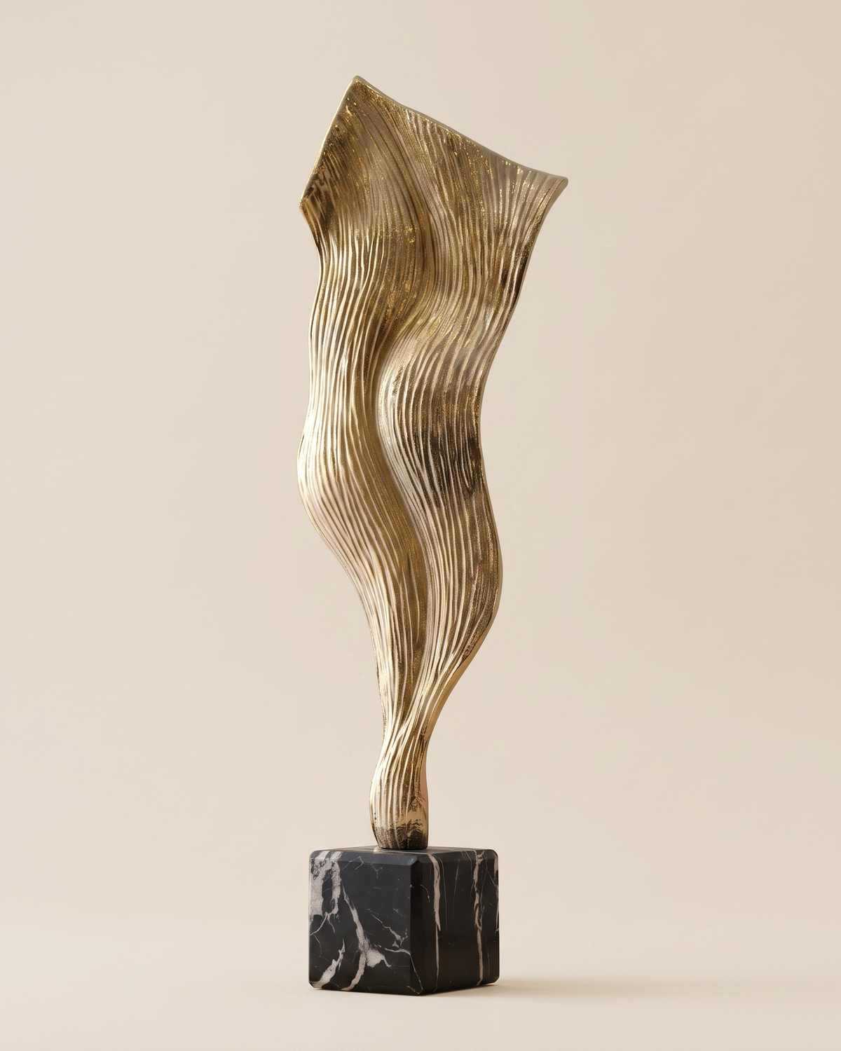 Wind Decorative Object Gold - striated gold brass draped sculpture on black marble cube, ivory studio background