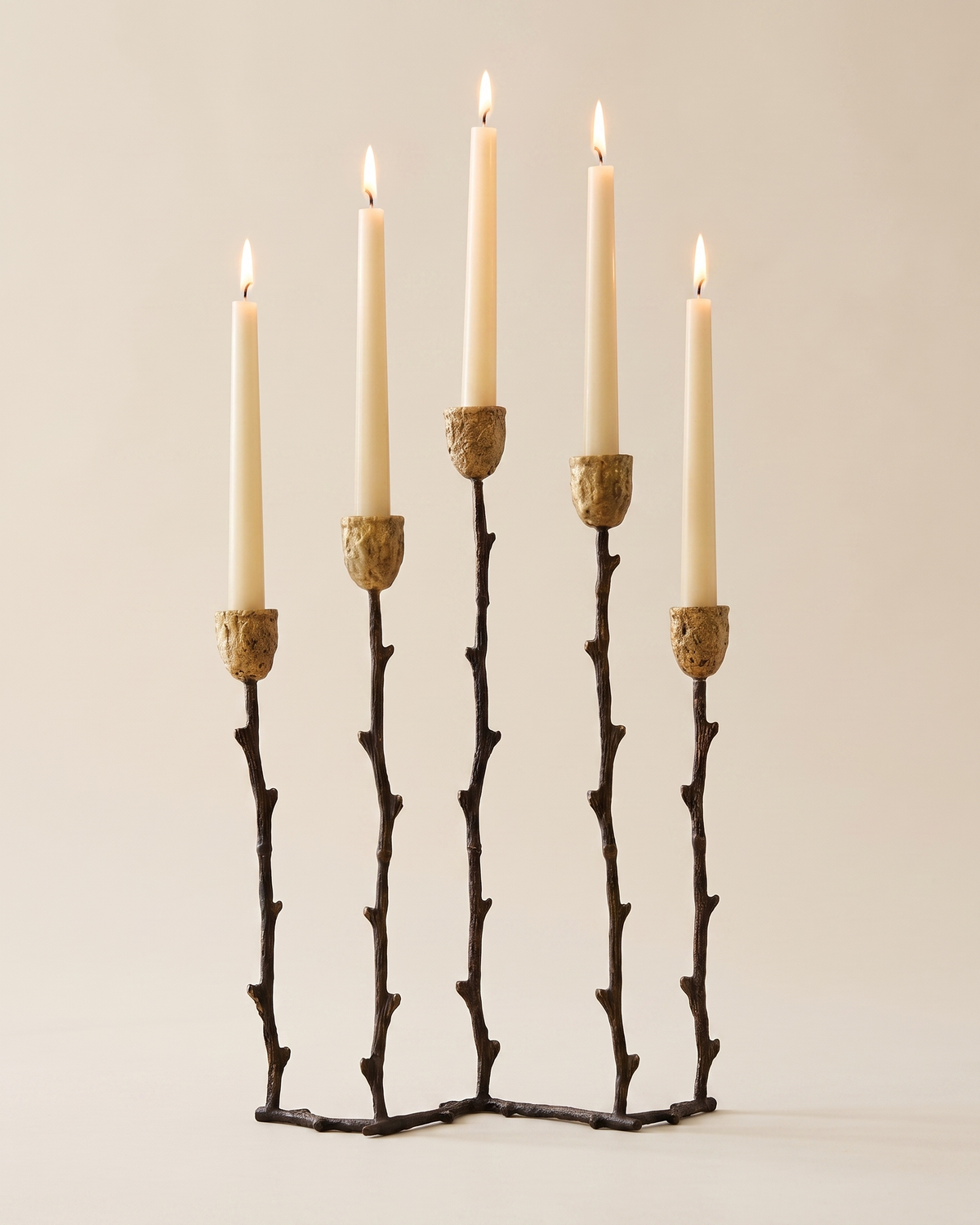 Branch Five-Arm Candelabra in Aged Gold Brass - with lit candles, ivory studio background
