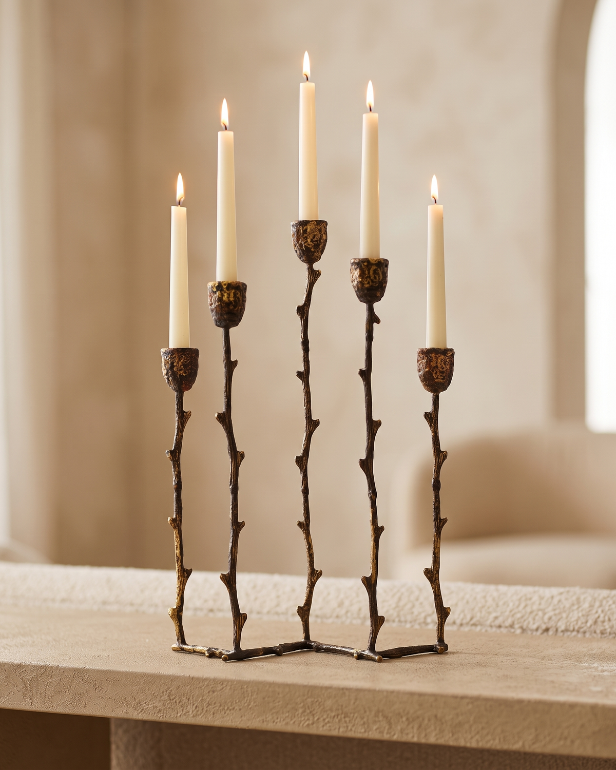 Branch Five-Arm Candelabra in Silvered Brass - with lit candles, styled on a warm beige console in a cosy interior