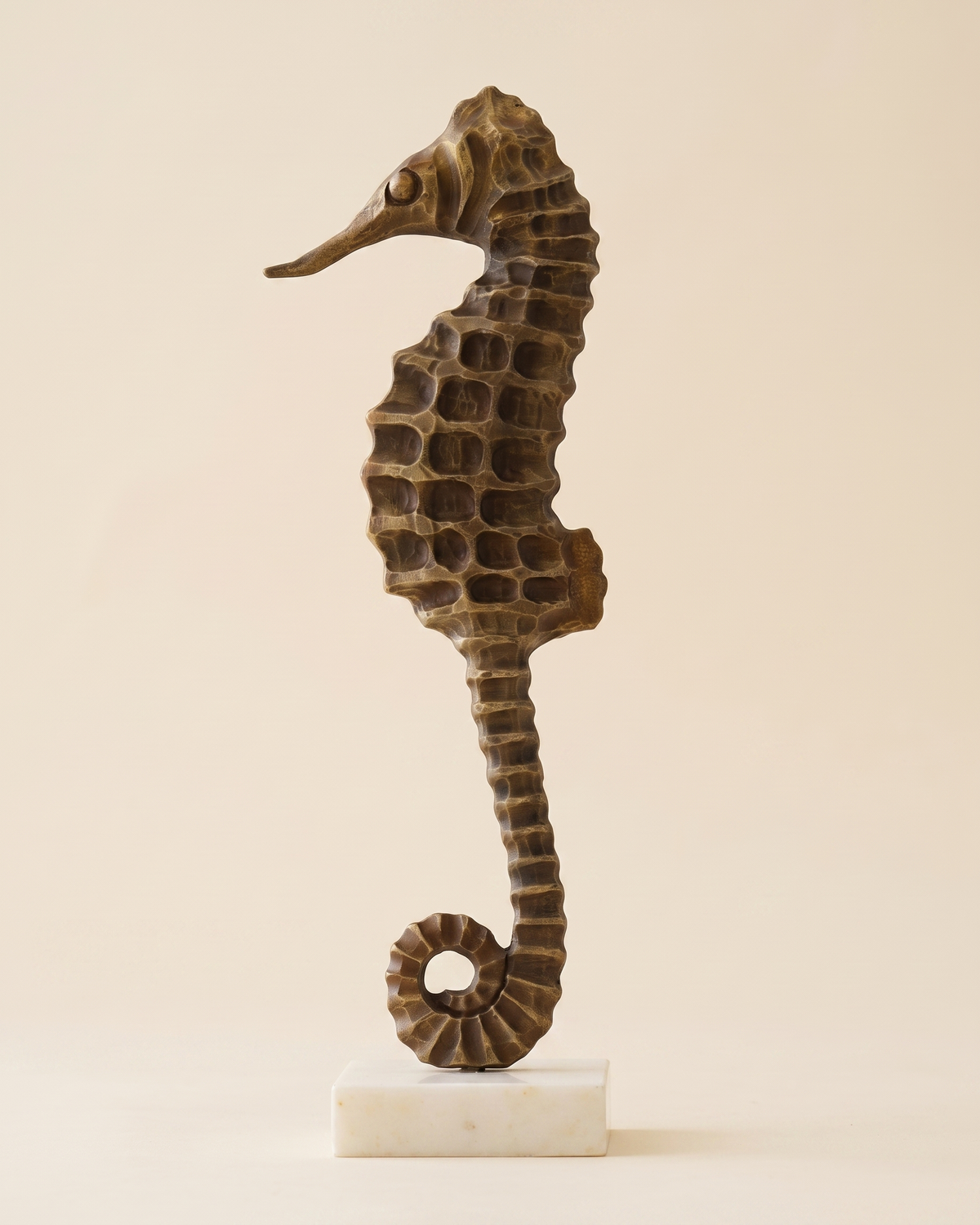 Brass Seahorse Decorative Object Antiqued - honeycomb textured bronze seahorse on white marble base, ivory studio background