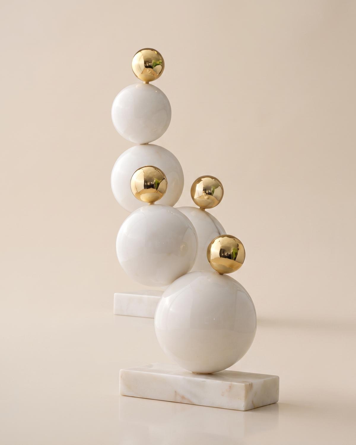 Bubble Decorative Object IV - two stacked white marble and gold sphere sculptures, ivory studio background