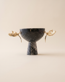 Footed bowl with two gold phoenix figures in dark veined marble on a pale ivory studio background