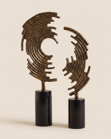 Half Icon Decorative Object VI - two antiqued bronze concentric arc crescents on black marble bases, ivory studio background