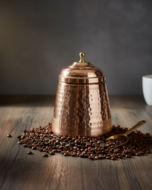 Copper container with lid on coffee beans on a wooden surface