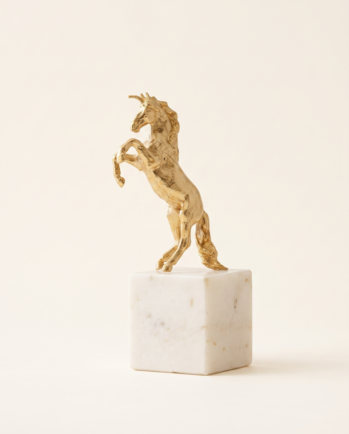 Golden Unicorn Sculpture on White Marble Base
