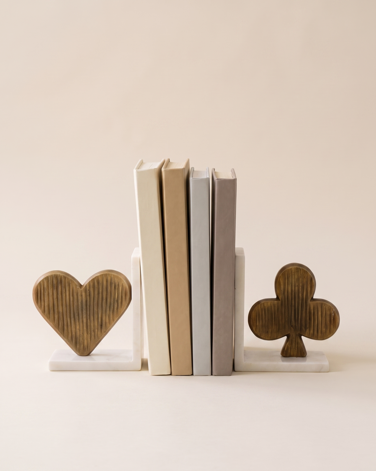 Luxury Spade & Club Bookend Set on Marble Base, Modern Sculptural Shelf Decor - studio view on ivory background, holding a row of plain books