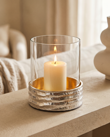 Molten Brass Glass Candlestick II Large - with lit candle, styled on a warm beige console in a cosy interior