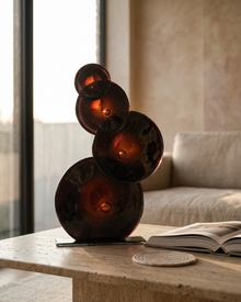 Quadruple glass bubble sculpture backlit on a travertine coffee table