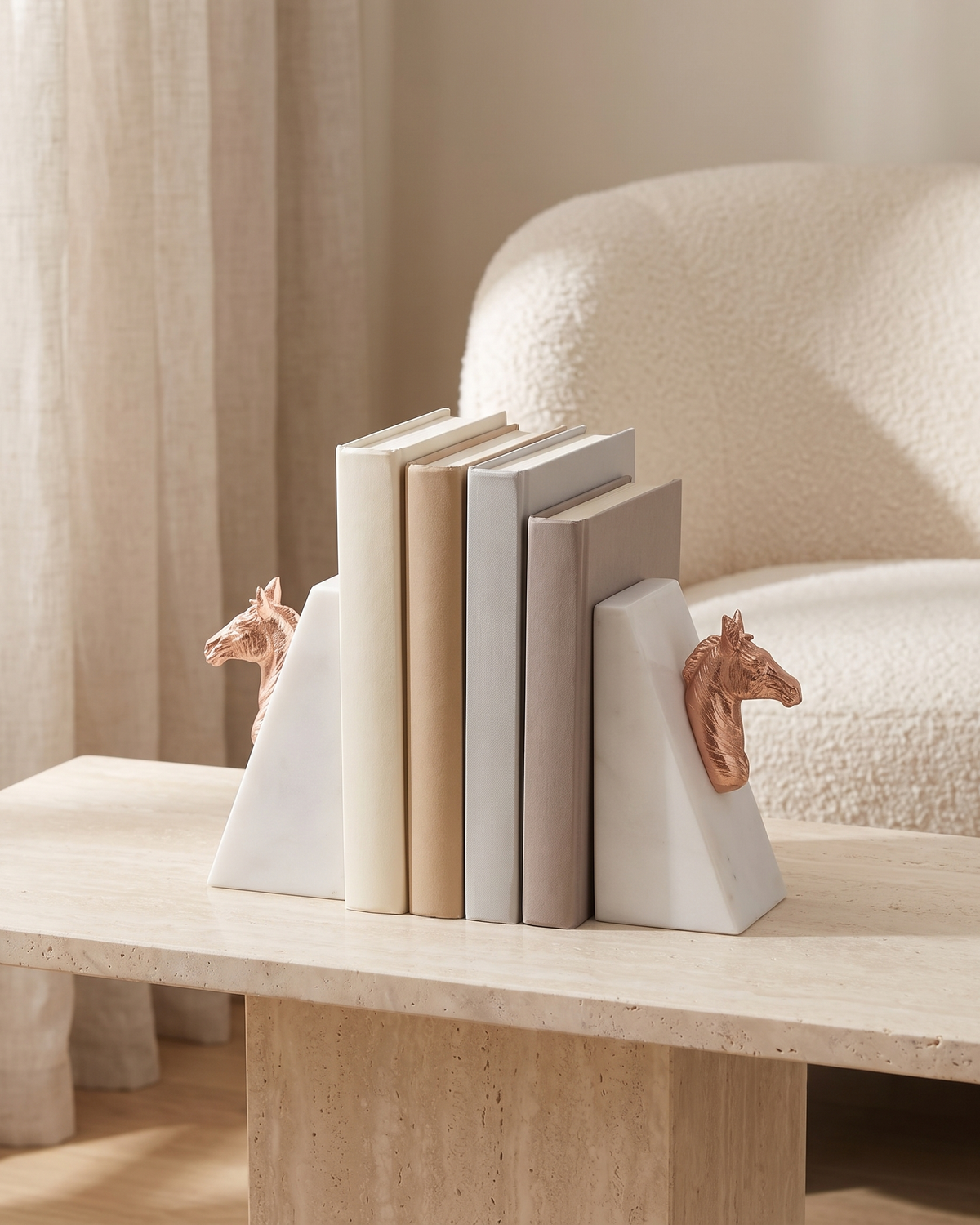 Rose Gold Horse Head Bookends with White Marble Base - styled on a travertine console holding plain books