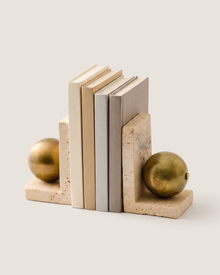 Travertine Book Stand with Brass Sphere - studio view on ivory background, holding a row of plain books