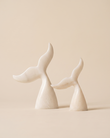 Whale Tail Decorative Object II - two cream marble whale tail sculptures, ivory studio background
